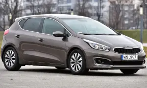 Brązowa Kia Ceed 1.6 benzyna z polskimi tablicami rejestracyjnymi WN 2937J zaparkowana na zewnątrz.