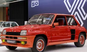 Czerwony Renault 5 Turbo z lat 80. błyszczy na wystawie. Charakterystyczne logo "TURBO" na drzwiach i pomarańczowe akcenty podkreślają jego sportowy charakter.