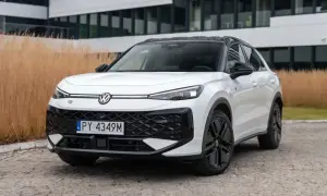 Biały Volkswagen ID.4, jeden z nowoczesnych volkswagen modele, zaparkowany przed budynkiem z przeszkloną fasadą.