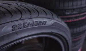 Zbliżenie na oponę samochodową z widocznym rozmiarem 205/45R17. W tle widać kolejne opony, sugerujące wybór rozmiarów opon.