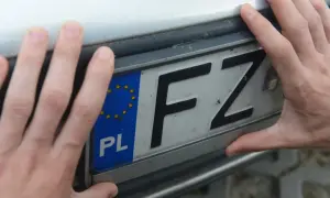 Dwie dłonie trzymają polską tablicę rejestracyjną z literami FZ. To ważny krok w procesie pwa rejestracja.