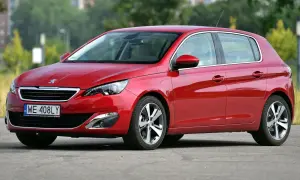 Czerwony Peugeot 308 T9 na tle zieleni, z widocznym numerem rejestracyjnym WE 408LY.