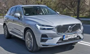 Srebrne Volvo XC60 w ruchu ulicznym. Kierowca za kierownicą. Sprawdź volvo xc60 wymiary, by poznać jego gabaryty.