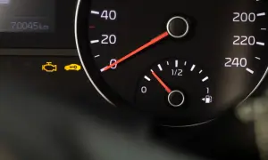 Kontrolka silnika i kluczyka na desce rozdzielczej, obok wskaźników prędkości i paliwa.
