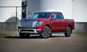Czerwony Nissan Titan stoi przed dużymi białymi zbiornikami.