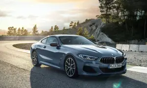 Eleganckie BMW 840i na zakręcie toru wyścigowego, z malowniczym krajobrazem w tle.
