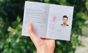 Międzynarodowe prawo jazdy z fotografią mężczyzny i pieczęciami. Dokument zawiera informacje o kategoriach pojazdów i wykluczeniach.