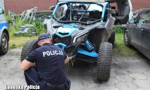 Policjant w mundurze bada quada z niebieskimi elementami.