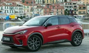 Czerwony Lexus LBX na tle nadmorskiego miasteczka. Sprawdź, jaka jest lexus lbx cena i zacznij planować wakacje!