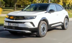 Biały Opel Mokka z czarnym dachem jedzie po drodze. Sprawdź atrakcyjną opel mokka cena!