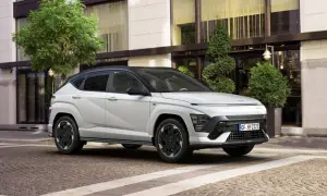 Nowy Hyundai Kona w białym kolorze, zaparkowany przed eleganckim budynkiem. Sprawdź atrakcyjną hyundai kona cena!