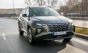 Szary Hyundai Tucson 1.6 T-GDI w ruchu drogowym, z widocznym grillem i światłami LED.