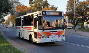 Autobus komunikacji miejskiej z napisem "TURBUSS" na tablicy kierunku, na ulicy w jesienny dzień. Rejestracja ELU.