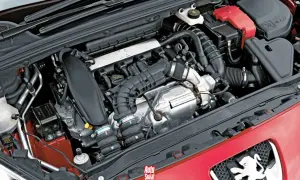 Silnik 1.6 THP w czerwonym Peugeocie, z widocznymi elementami układu dolotowego i chłodzenia.