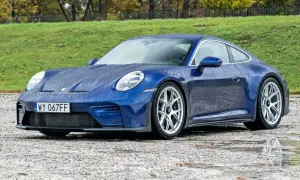 Niebieski Porsche 911 na mokrej nawierzchni. Sprawdź aktualną porsche 911 cena.