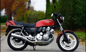 Czerwony motocykl Honda CBX 1000 z lat 80. na tle jesiennej przyrody.