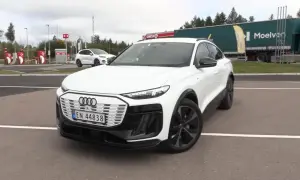 Białe Audi Q6 e-tron na parkingu, obok stacji Circle K. Zastanawiasz się nad audi q6 e-tron cena?