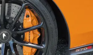 Pomarańczowy zacisk hamulcowy McLaren z oznaczeniami opon 225/35 ZR19 na czarnej feldze.