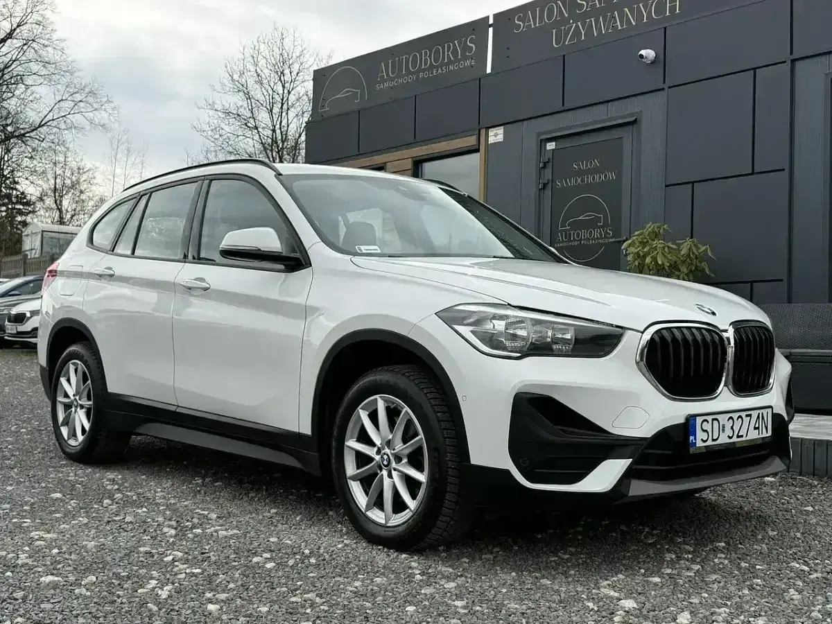 Białe BMW X1 przed salonem samochodowym. Sprawdź atrakcyjną bmw x1 cena!