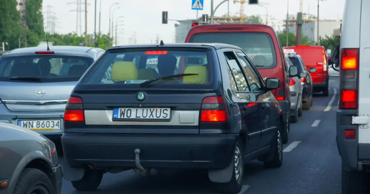 Korek uliczny, gdzie widać samochody z indywidualnymi tablicami rejestracyjnymi, np. "WO LUXUS".
