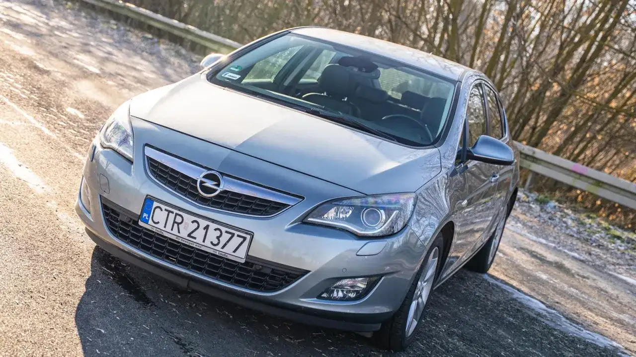 Srebrny Opel Astra J 1.6 benzyna na drodze.