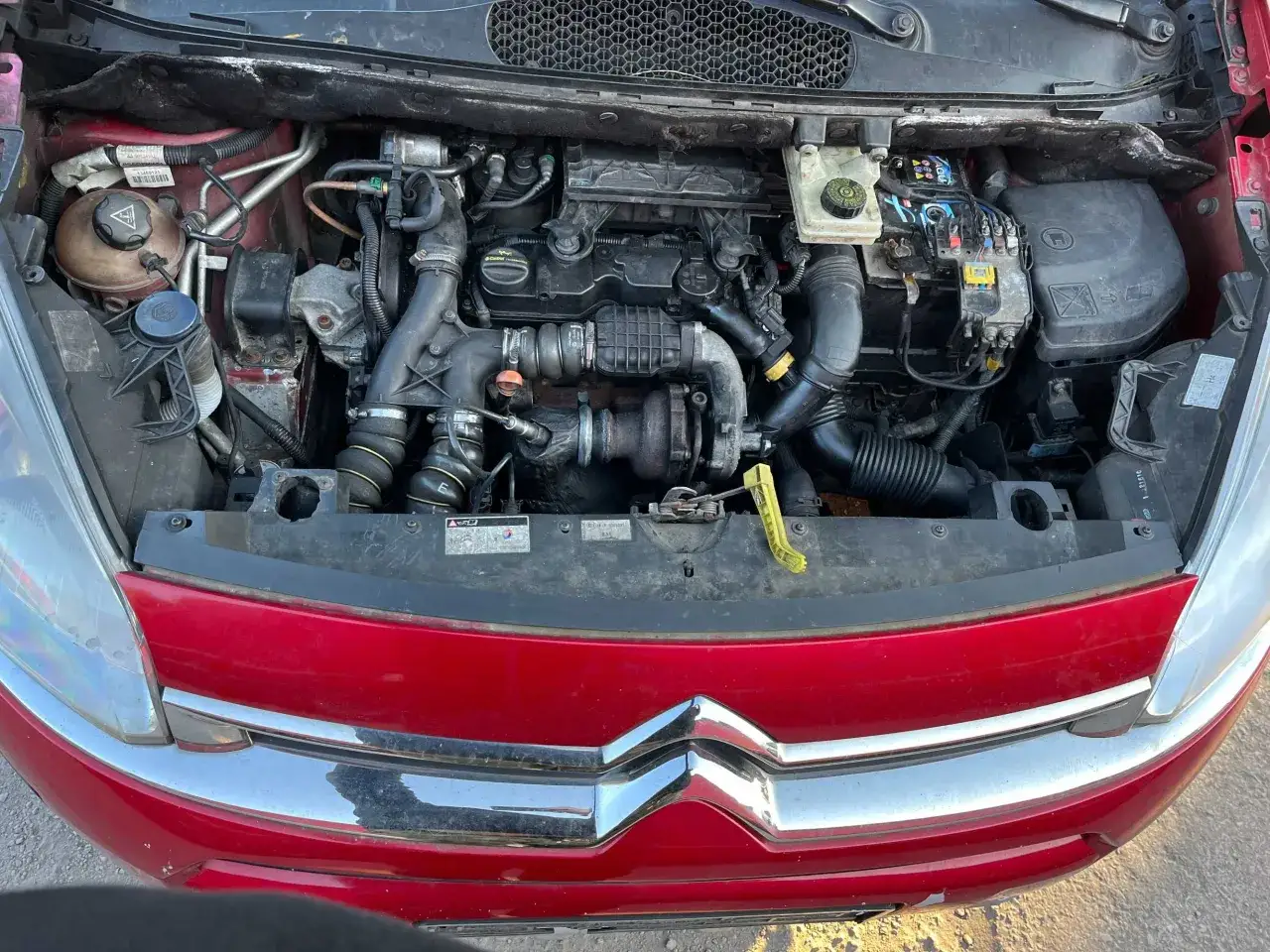 Silnik diesla Citroen Berlingo 1.6 HDI, z widocznym turbosprężarką i przewodami.