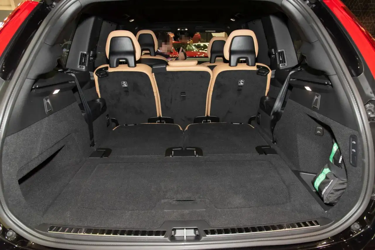 Wnętrze Volvo XC90 z rozłożonymi siedzeniami. Duży bagażnik, idealny na rodzinne wyjazdy, pokazuje praktyczne wymiary tego SUV-a.