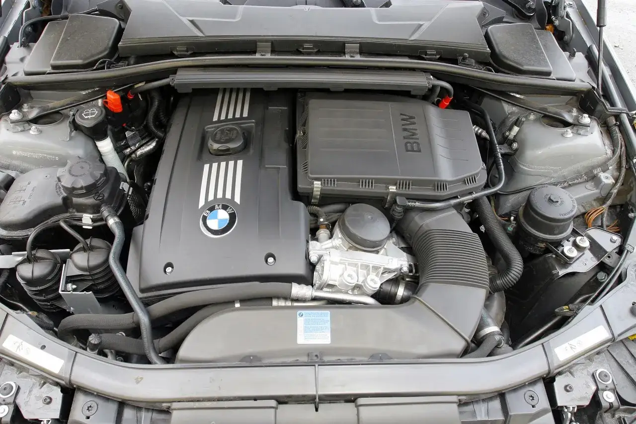 Silnik BMW 325i z widocznym logo BMW i elementami układu dolotowego.