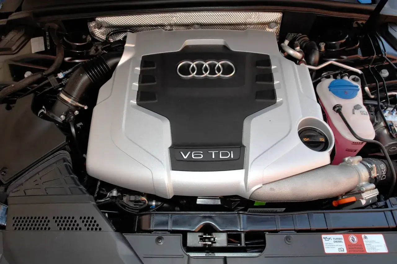 Silnik V6 TDI Audi, gotowy do pracy. Potężna jednostka napędowa z charakterystycznym logo.