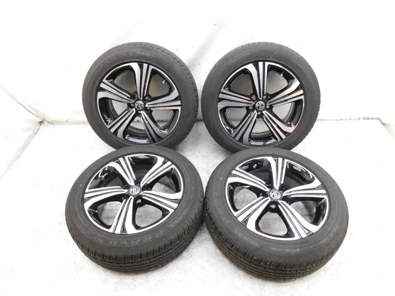 Cztery felgi aluminiowe z oponami do MG ZS Classic. Elegancki wzór z polerowanymi ramionami.