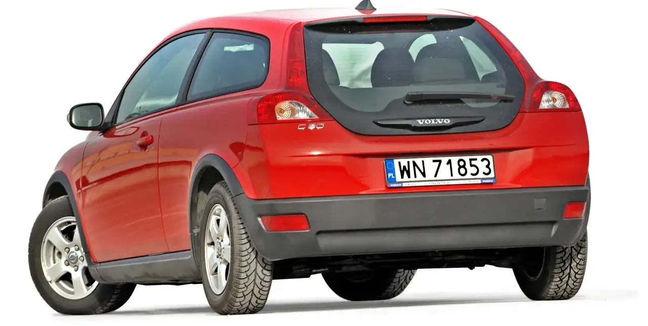Czerwony volvo hatchback C30 z polskimi tablicami rejestracyjnymi WN 71853, widok od tyłu.