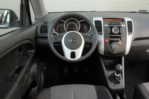 Wnętrze Kia Venga 1.4 benzyna: kierownica z logo Kia, deska rozdzielcza z radiem i nawiewami, dźwignia zmiany biegów.