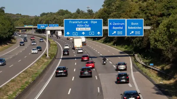 Autostrada w Niemczech, ruch samochodowy. Znaki drogowe wskazują kierunki: Frankfurt, Olpe, Kolonia, Bonn. Uważaj na mandaty w niemczech!