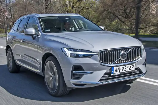 Srebrne Volvo XC60 w ruchu ulicznym. Kierowca za kierownicą. Sprawdź volvo xc60 wymiary, by poznać jego gabaryty.