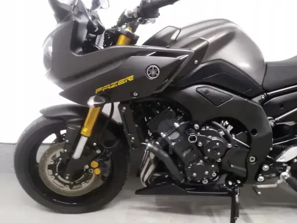 Ciemnoszary motocykl Yamaha FZ8 z żółtym napisem "FAZER" na owiewce. Widoczny silnik, przednie zawieszenie i koło.