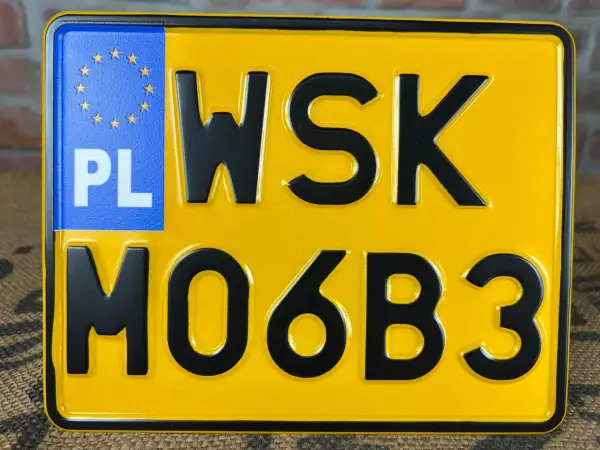 Żółta tablica rejestracyjna z literami WSK i cyframi MO6B3. PL.