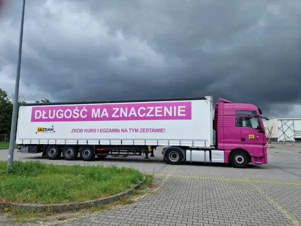 Różowa ciężarówka z napisem "Długość ma znaczenie. Zrób kurs i egzamin na tym zestawie!" zachęca do zdobycia prawa jazdy kategorii C+E.