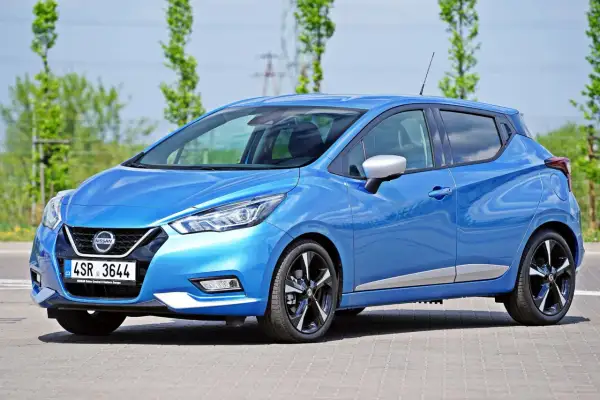 Błękitny Nissan Micra, jeden z popularnych nissan modele, zaparkowany na zewnątrz.