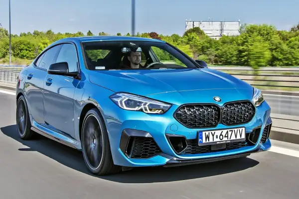 Niebieskie BMW 2 Gran Coupe pędzi autostradą. Kierowca skupiony na drodze.