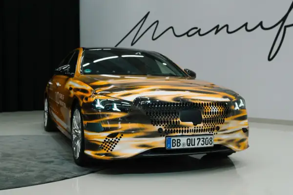 Pomarańczowy w223 z grafiką przypominającą płomienie. Na masce i bokach widoczne napisy "110 YEARS OF INNOVATION".