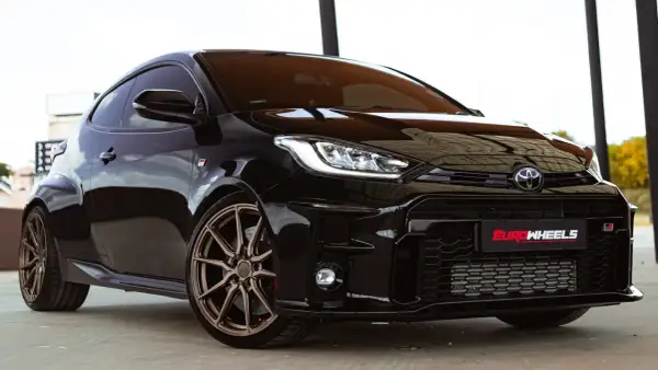 Czarny Toyota Yaris Sport z brązowymi felgami, gotowy do dynamicznej jazdy.