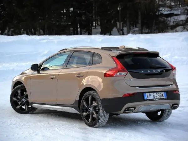 Brązowe Volvo V40 Cross Country na śniegu. Wiele pozytywnych volvo v40 opinie o tym modelu, szczególnie zimą.