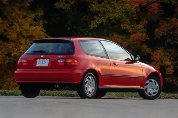 Czerwony Honda Civic Si z lat 90. na tle jesiennych drzew.