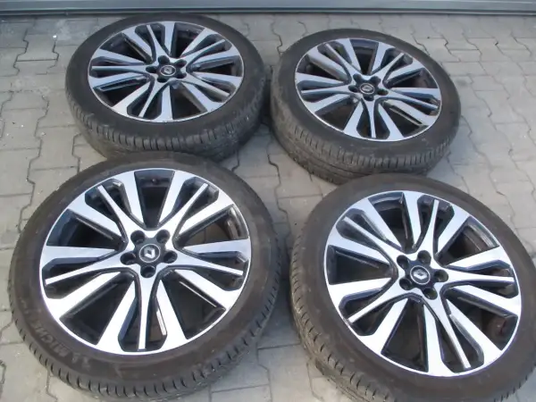 Cztery felgi aluminiowe Renault Initiale z oponami, gotowe do montażu.