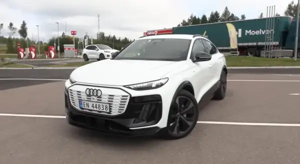 Białe Audi Q6 e-tron na parkingu, obok stacji Circle K. Zastanawiasz się nad audi q6 e-tron cena?